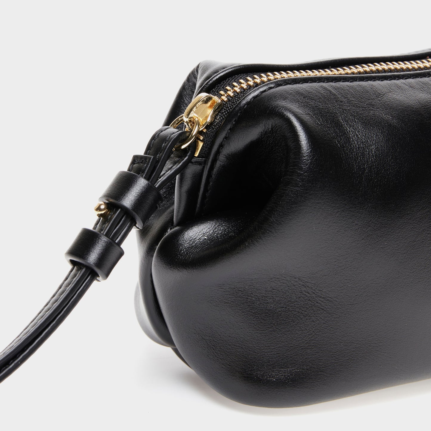 Close-up of zipper and texture on black leather mini beauty bag