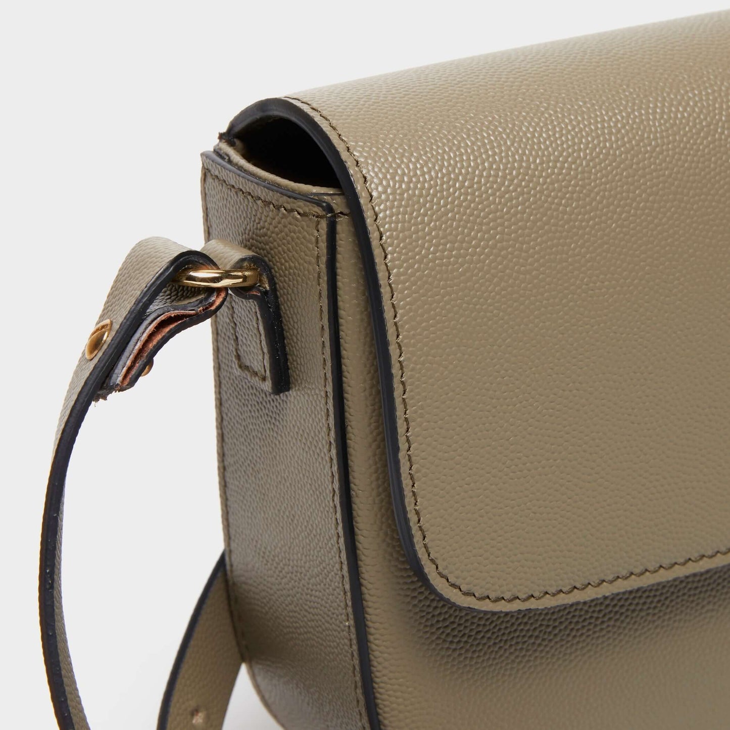 Close-up of curved stitching on beige calfskin crossbody bag