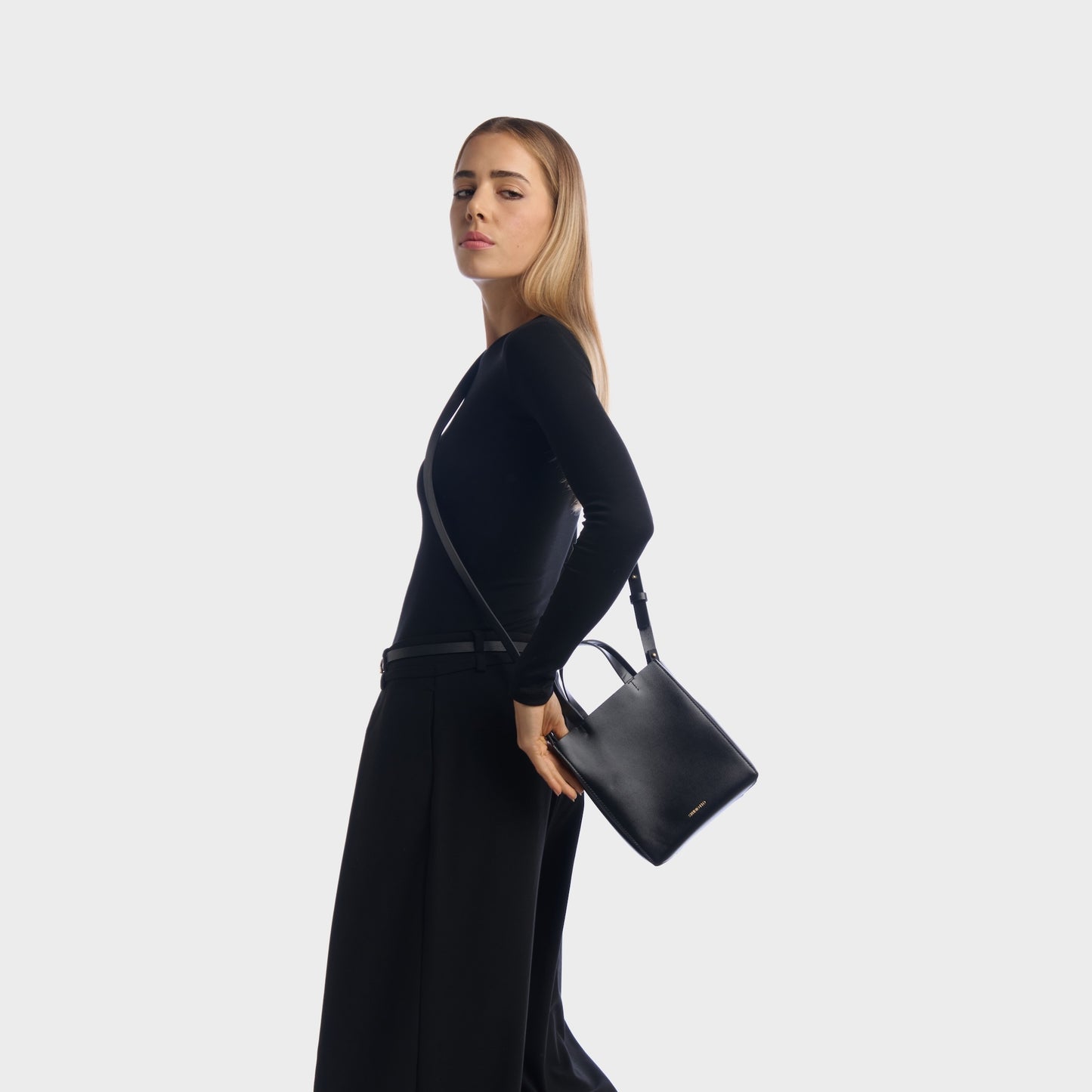 Woman wearing black structured mini shopper bag with shoulder strap