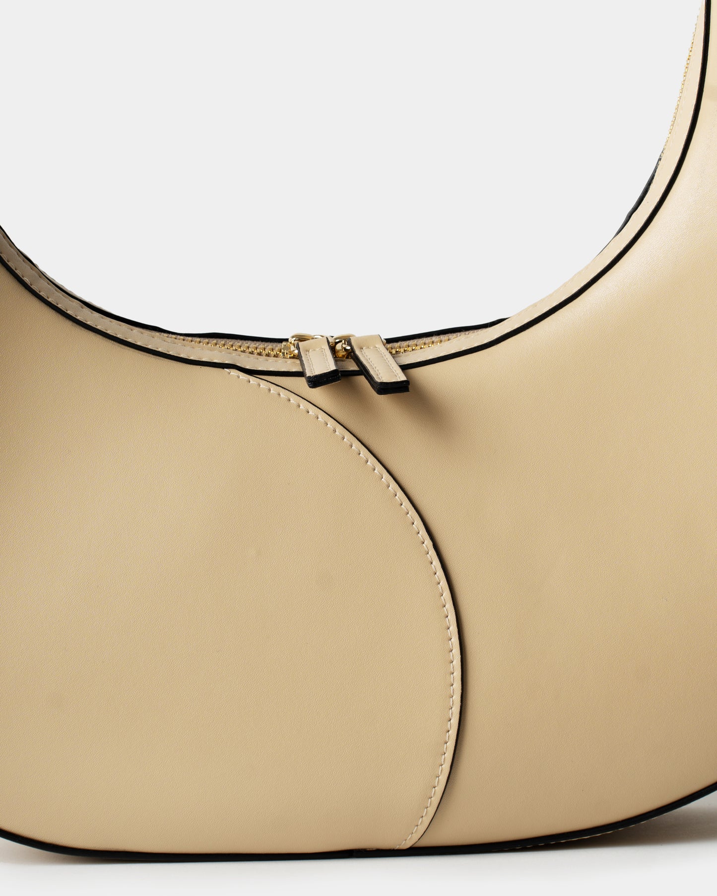 Detail of smooth cream leather and stitching on big crescent bag