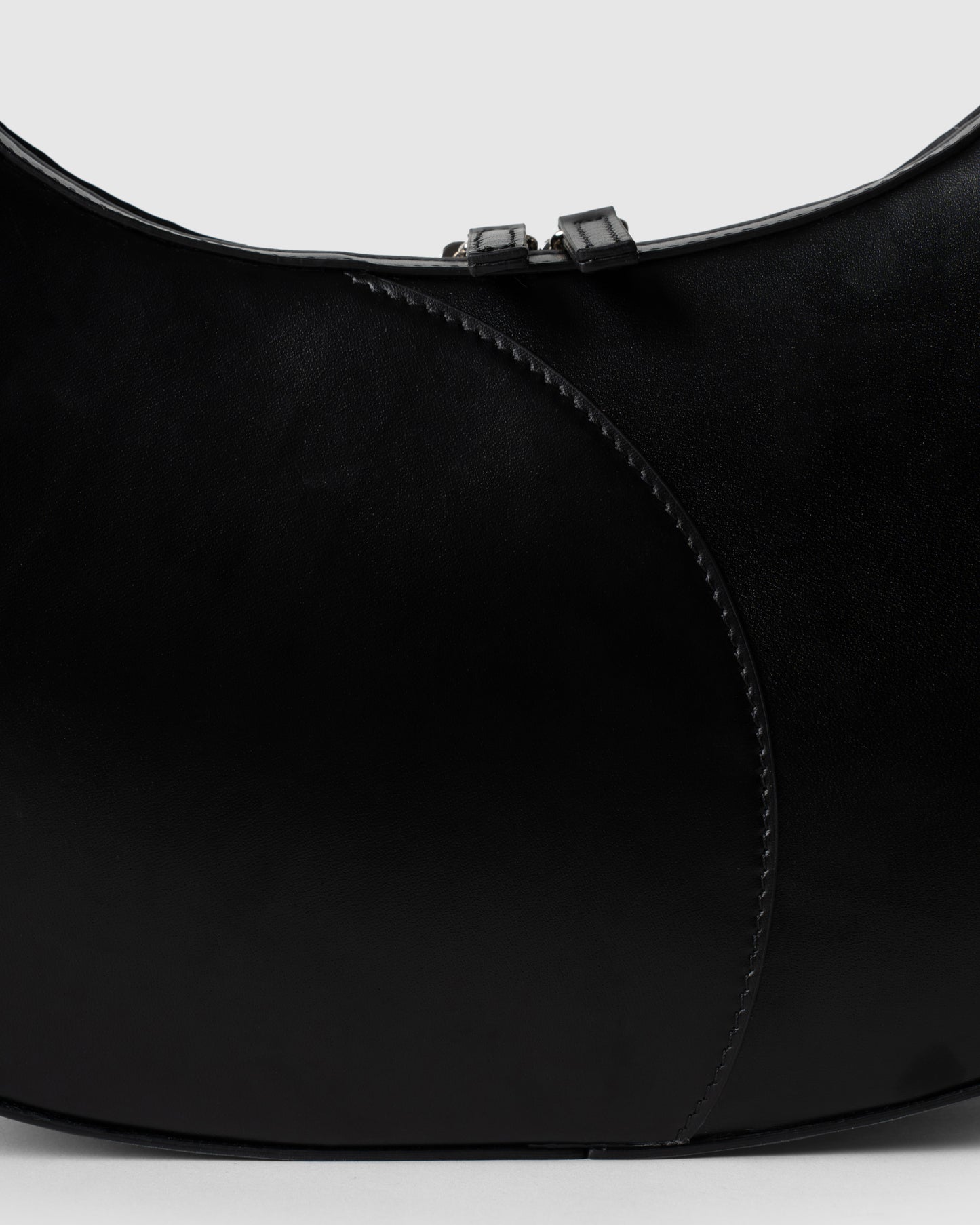 Detail of smooth black leather and stitching on big crescent bag