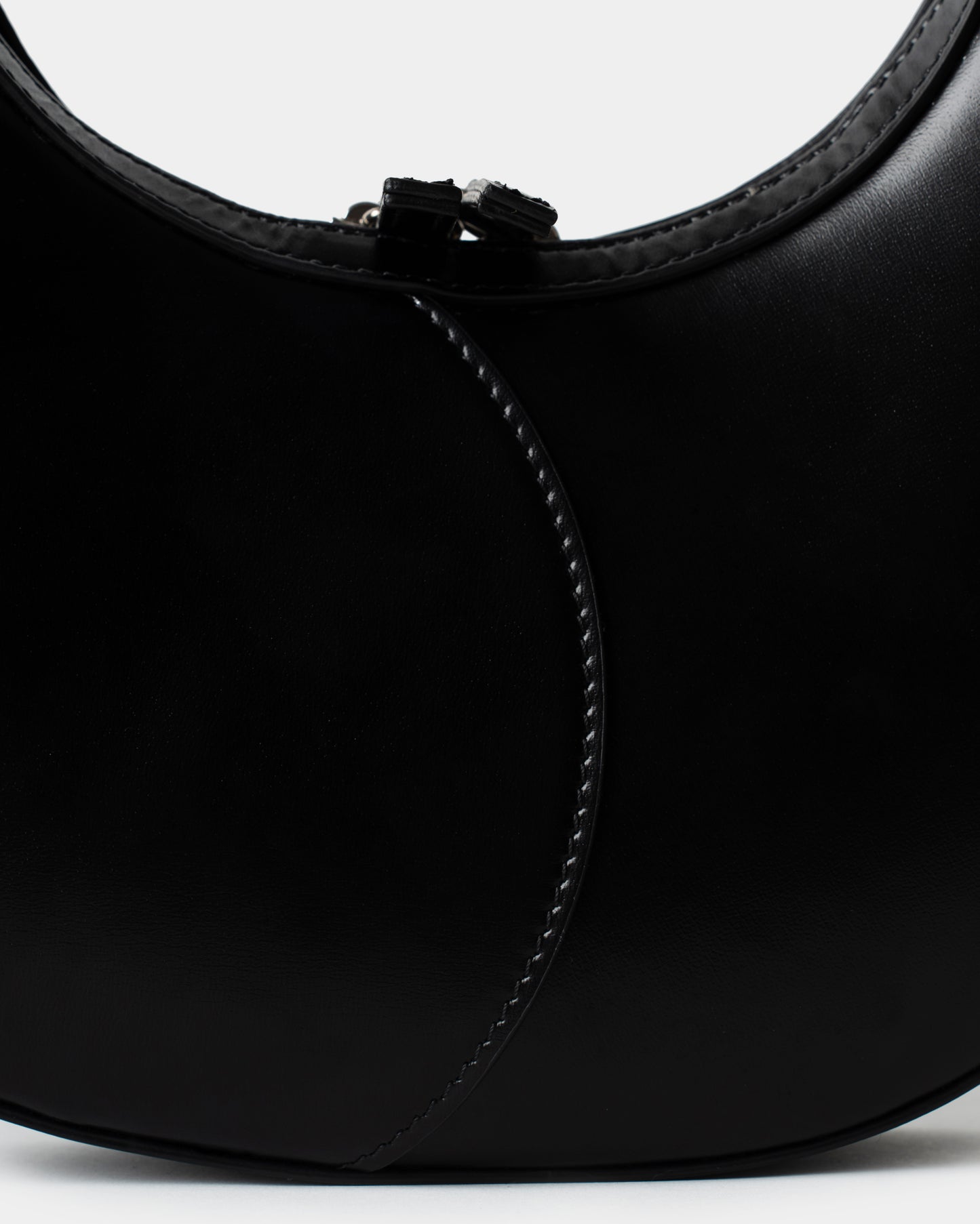 Black leather moon bag with contrast curved stitching and zip closure