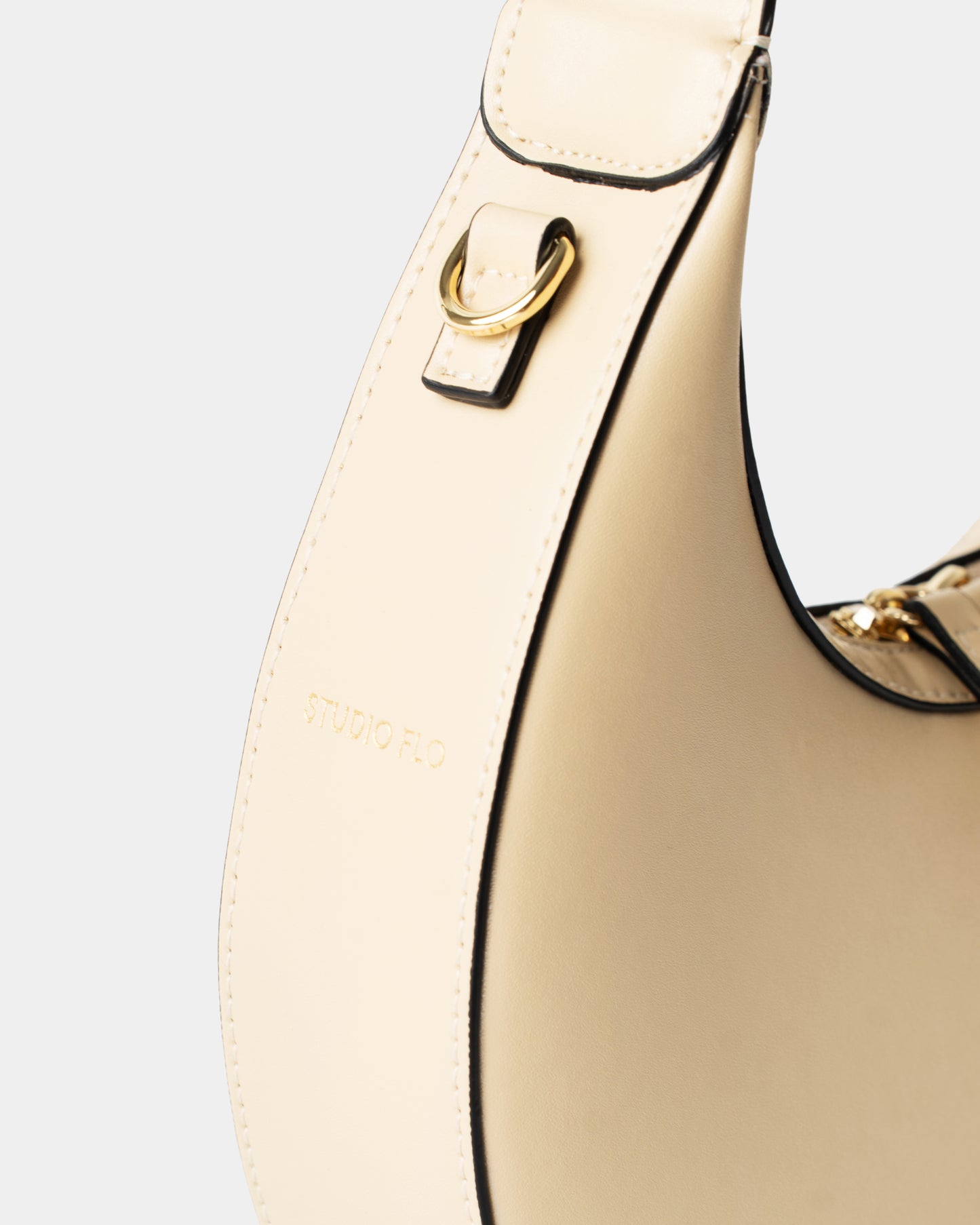 Detail of smooth cream leather and stitching on mini crescent bag