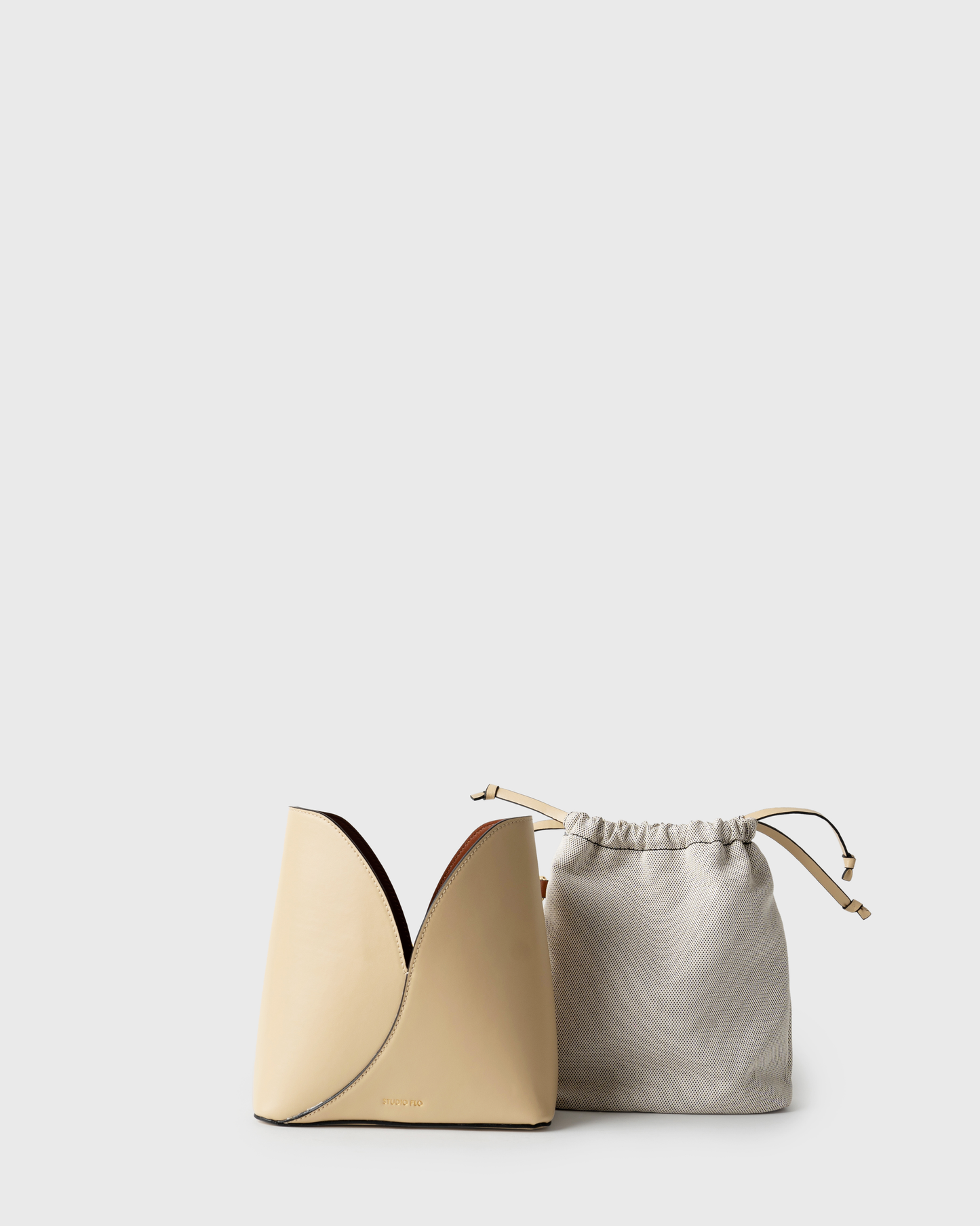 Structured cream leather bucket bag with contrast interior and silver hardware