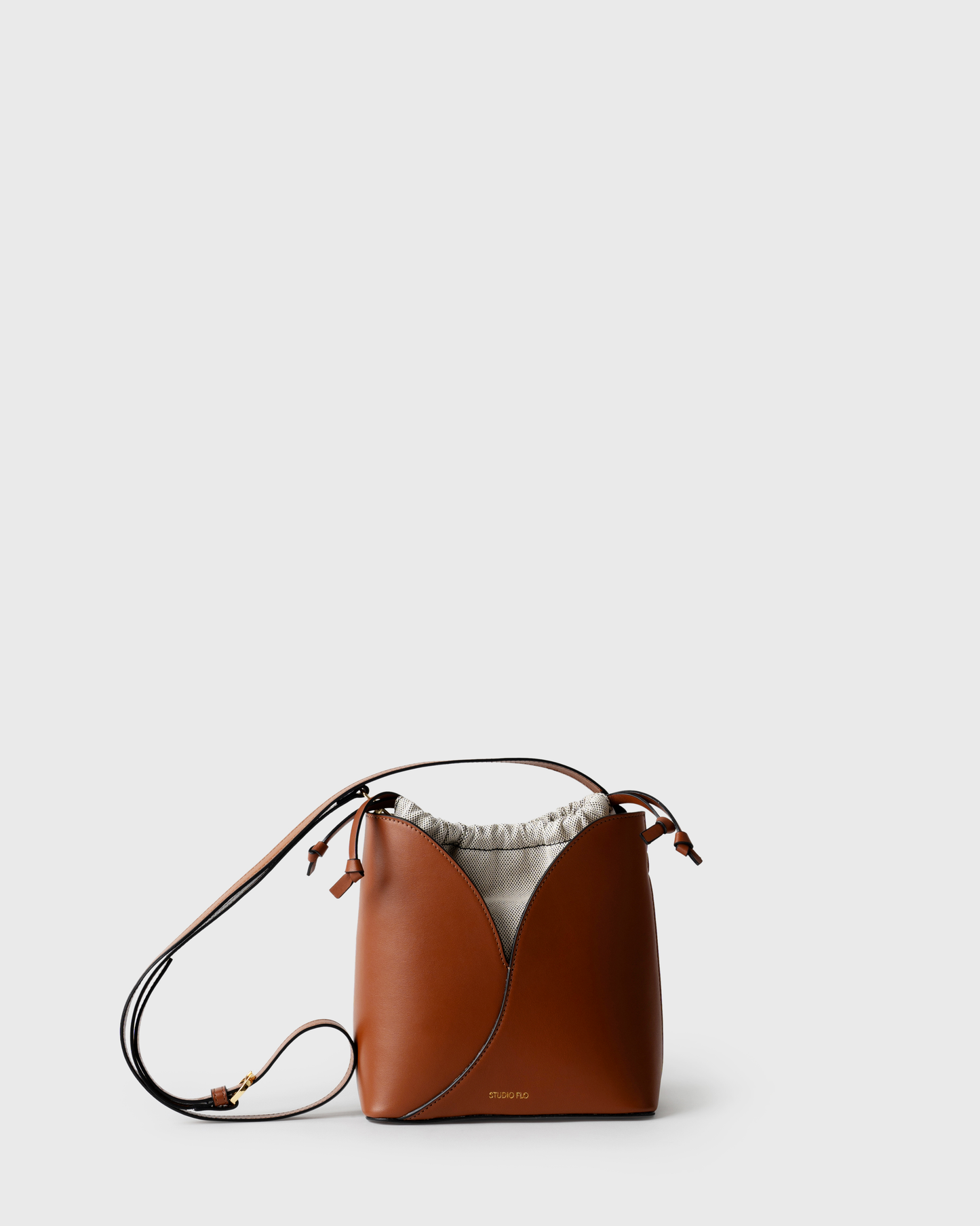 Compact bucket bag in cognac calf leather with curved top and handle