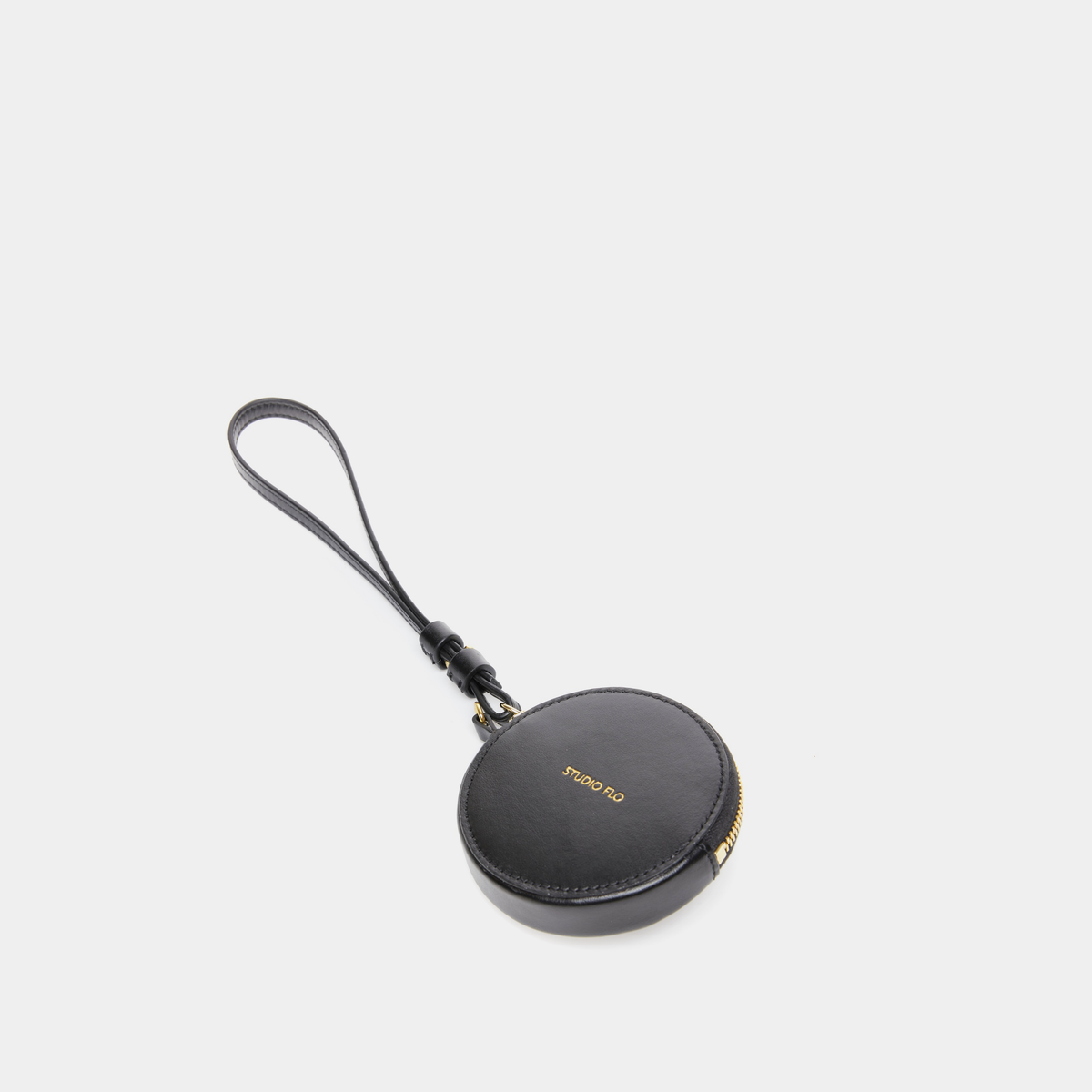 Porte-monnaie rond en cuir de veau, coloris noir de Studio Flo avec dragonne.