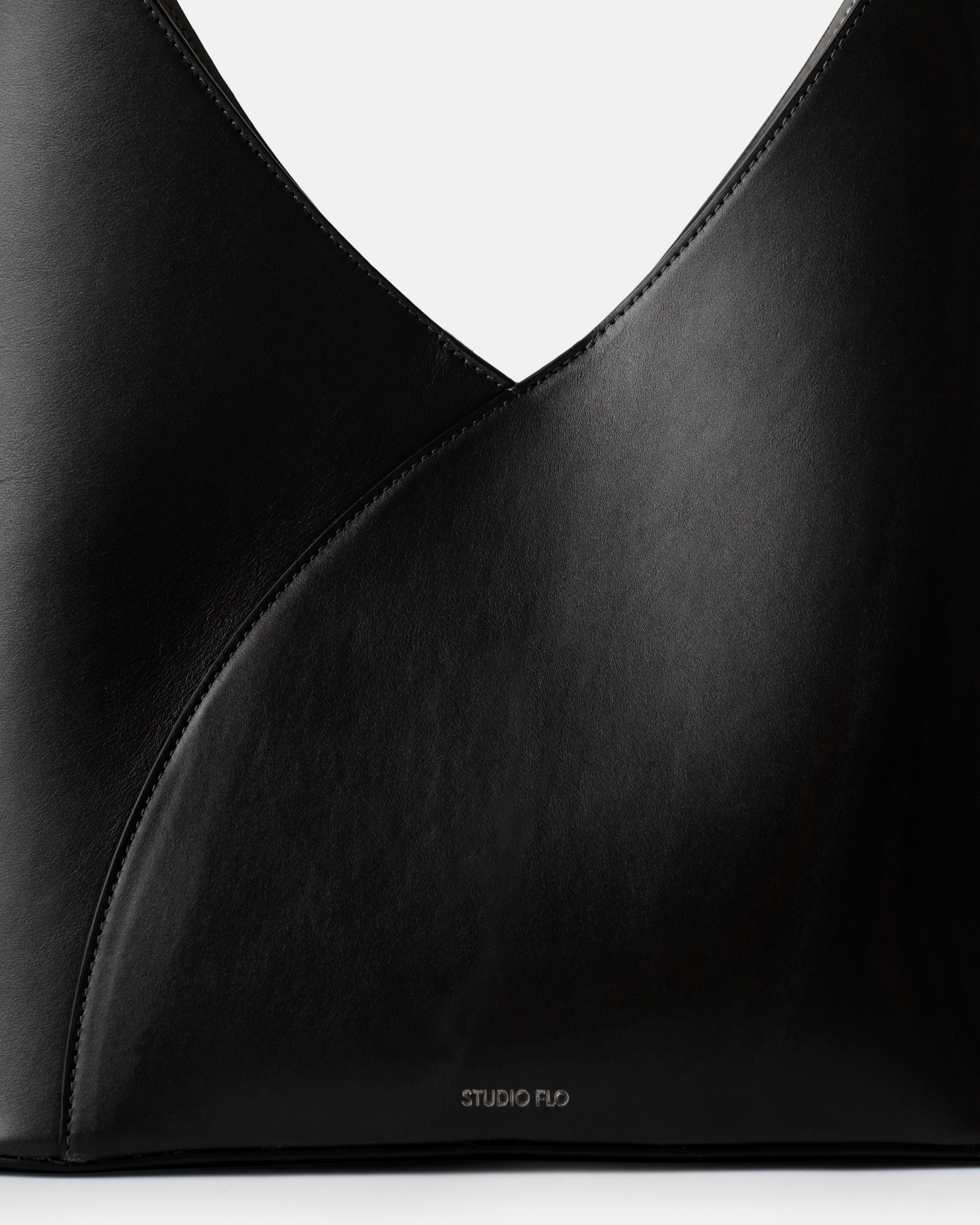 Close-up of structured leather handle on sculptural black bag