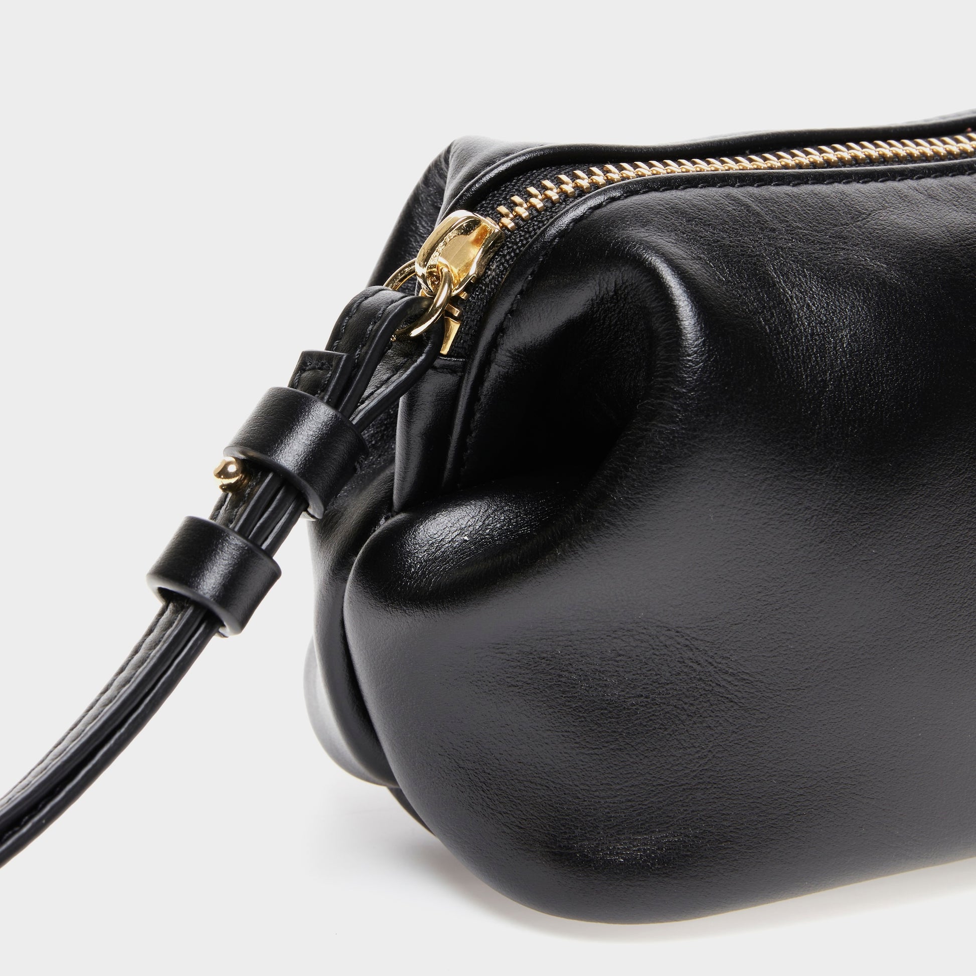 Close-up of zipper and texture on black leather mini beauty bag