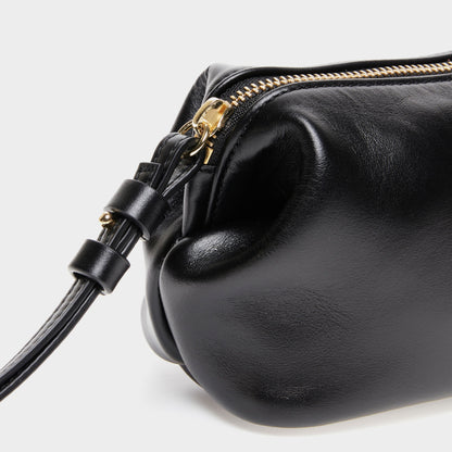 Close-up of zipper and texture on black leather mini beauty bag