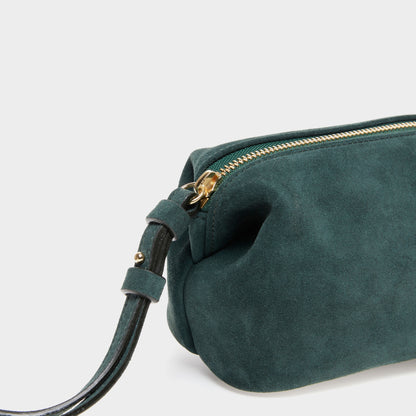 Close-up of soft suede texture and gold zipper on mini pouch