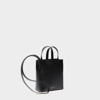 Mini handbag with adjustable strap in black calf leather