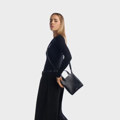 Woman wearing black structured mini shopper bag with shoulder strap