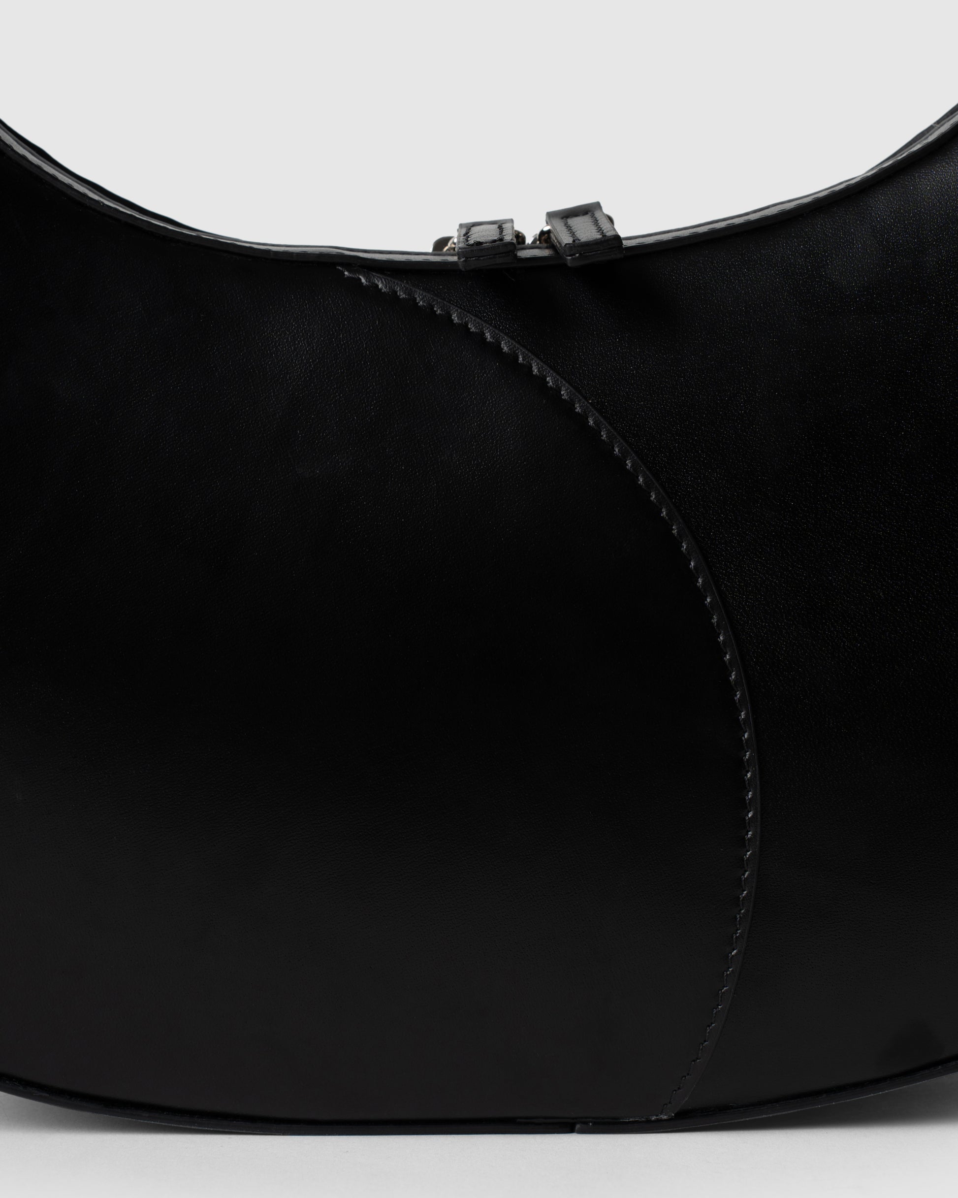 Detail of smooth black leather and stitching on big crescent bag