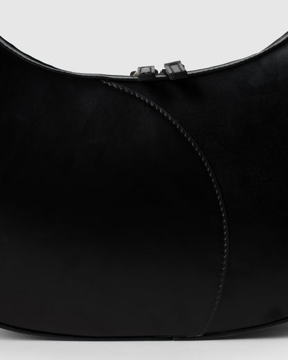Detail of smooth black leather and stitching on big crescent bag