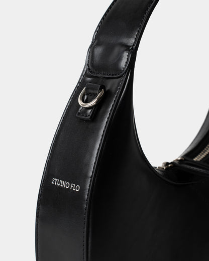 Detail of smooth black leather and stitching on mini crescent bag