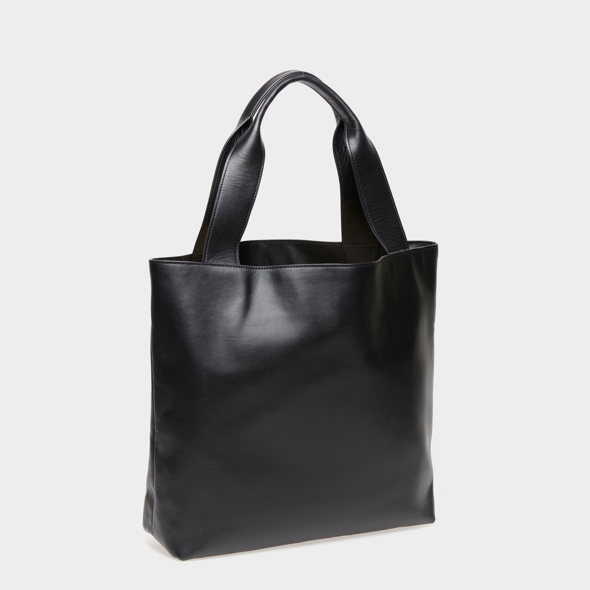 Angled view of the spacious Urban Tote black leather bag