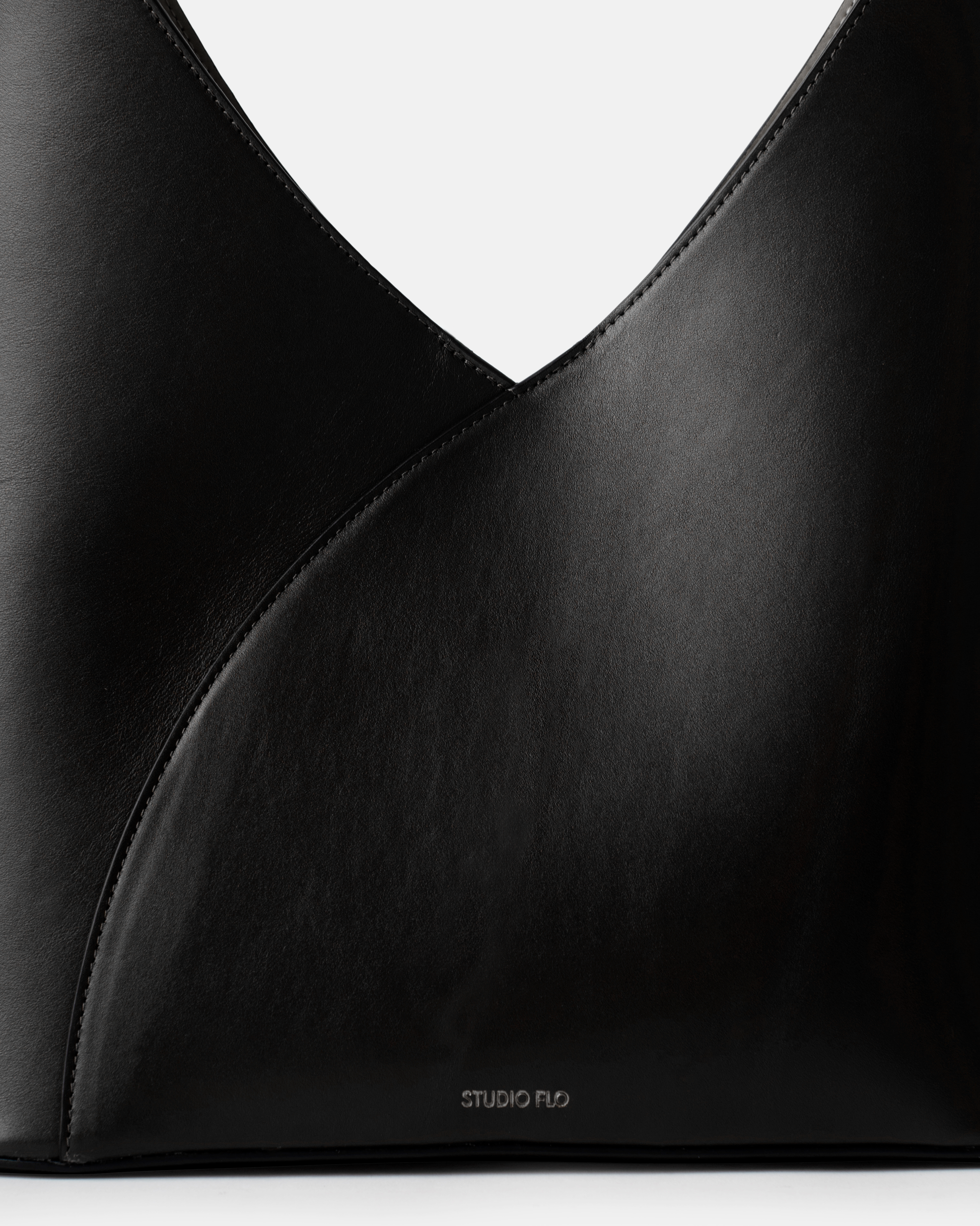 Close-up of structured leather handle on sculptural black bag